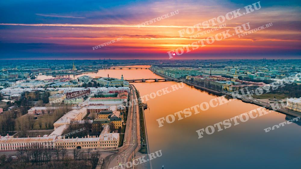 Этот снимок захватывает великолепный закатный вид на реку Неву и исторический центр Санкт-Петербурга. Отражение мягких закатных тонов в тихой воде реки придает городу особенно умиротворенное и величественное настроение. Видно множество мостов, пересекающих Неву, и исторические здания, расположенные вдоль набережной. Такая фотография идеально подойдет для использования в публикациях о путешествиях, в качестве иллюстрации в исторических и культурных материалах, а также как элемент украшения интерьеров, вдохновляющий на поездки и открытия.
